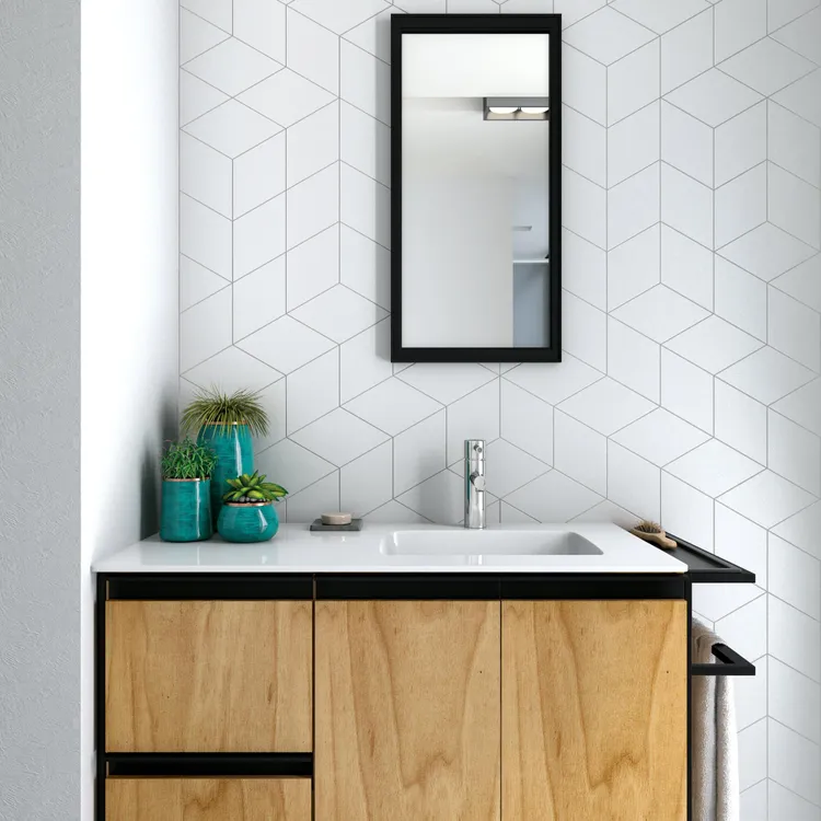 Łazienka ze ścianą wyłożoną białymi płytkami matowymi w kształcie rombu z drewnianą szafką z umywalką i lustrem w czarnej ramie