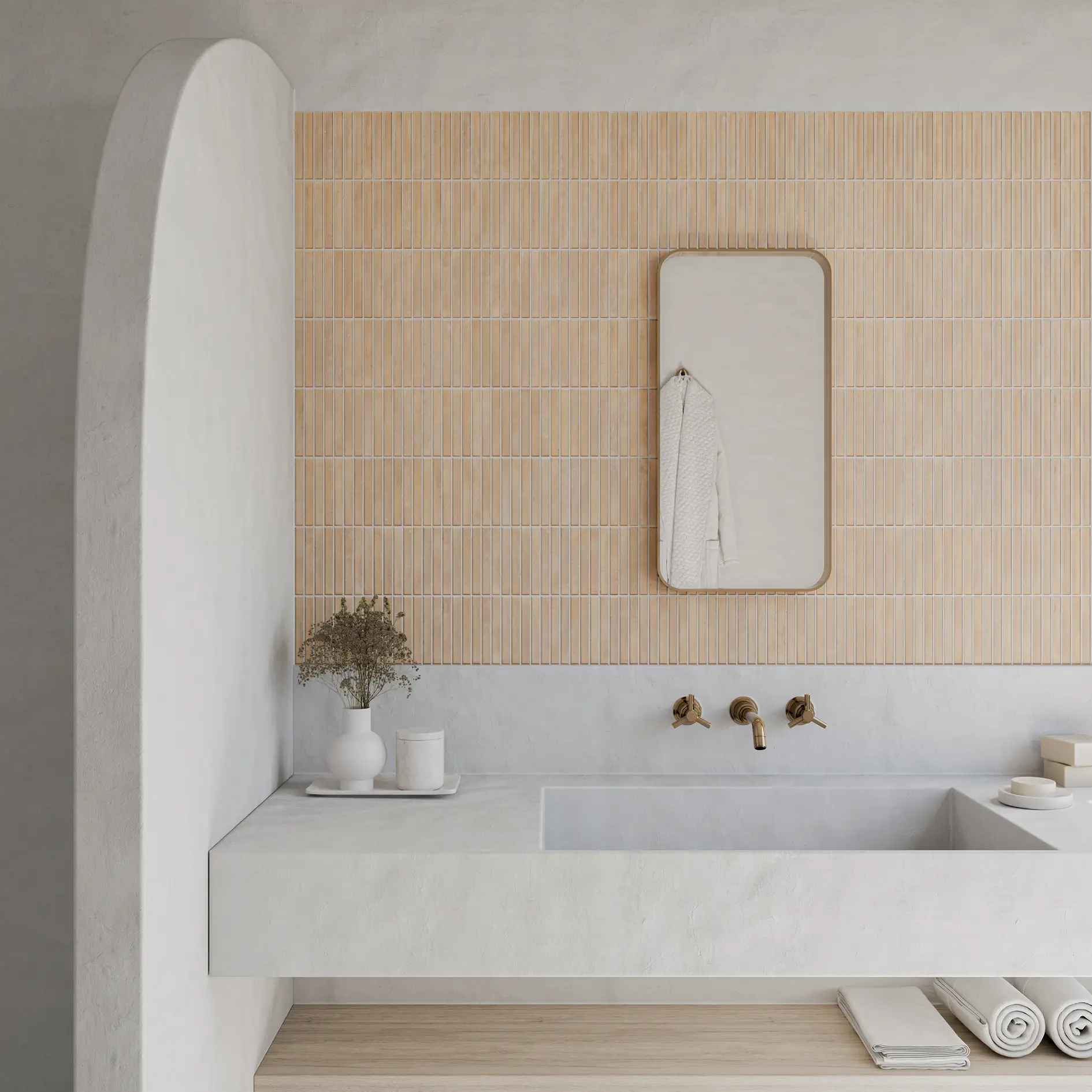 Łazienka ze ścianą wyłożoną ciepłymi, beżowymi płytkami, blatem z umywalką i lustrem