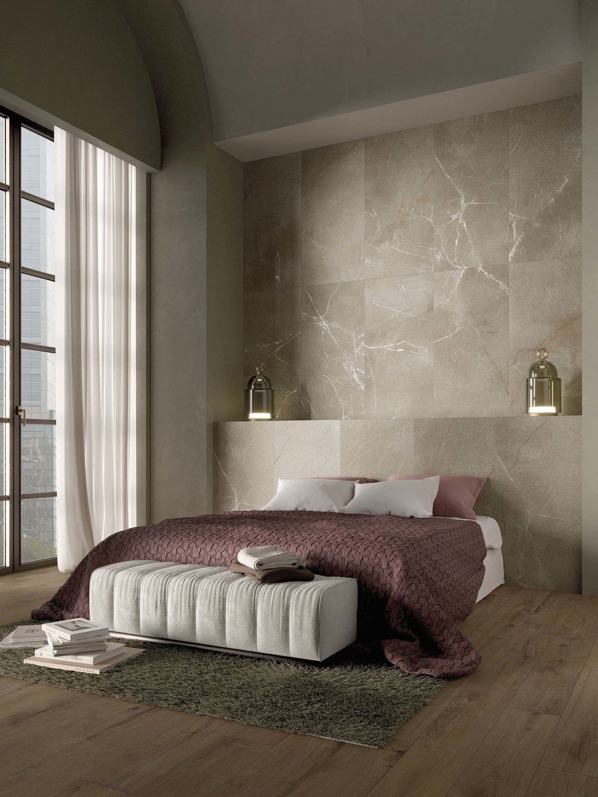 Sypialnia ze ścianą wyłożoną beżowymi płytkami imitującymi kamień z dużym łóżkiem, dywanem, książkami i dwoma lampkami