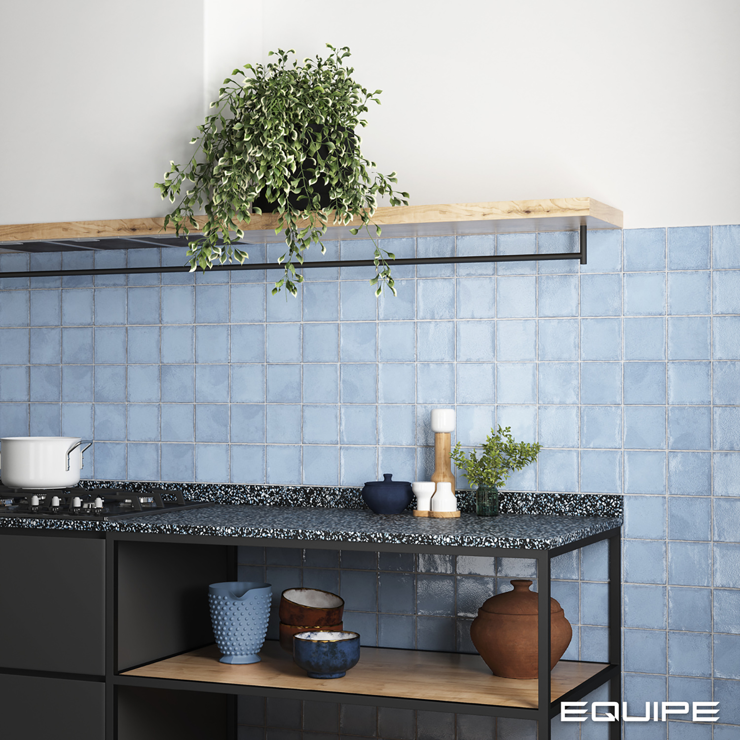 Ściana w kuchni wyłożona błękitnymi cegiełkami z czarnymi meblami z naczyniami i wiszącą półką z kwiatem