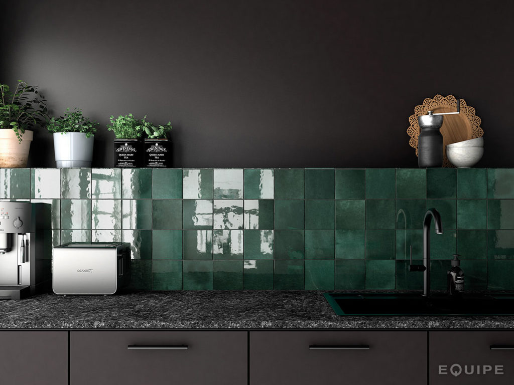 Ciemna kuchnia z fragmentem ściany nad czarnymi meblami wyłożoną zielonymi cegiełkami Artisan Moss Green kwadratowymi w połysku