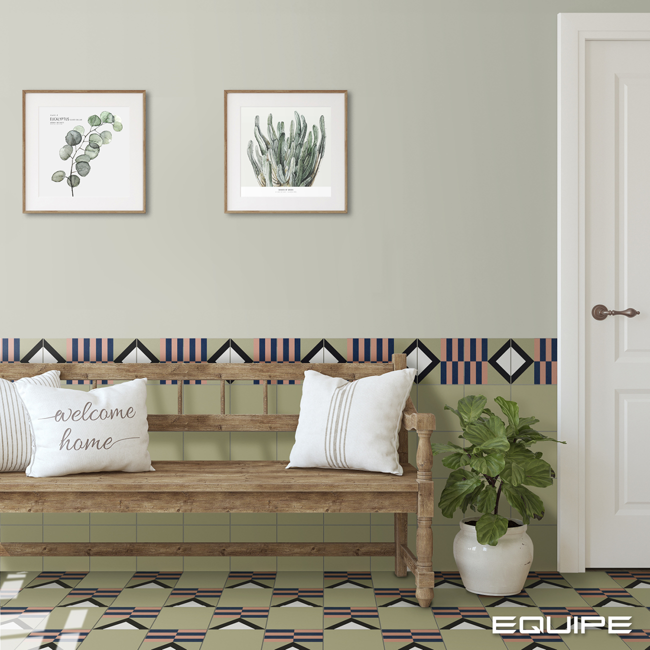 Korytarz wyłożony zielonymi płytkami bazowymi oraz kolorowymi patchworkowymi z drewnianą ławą, dwoma poduszkami, dwoma obrazami, kwiatem w białej donicy i białymi drzwiami