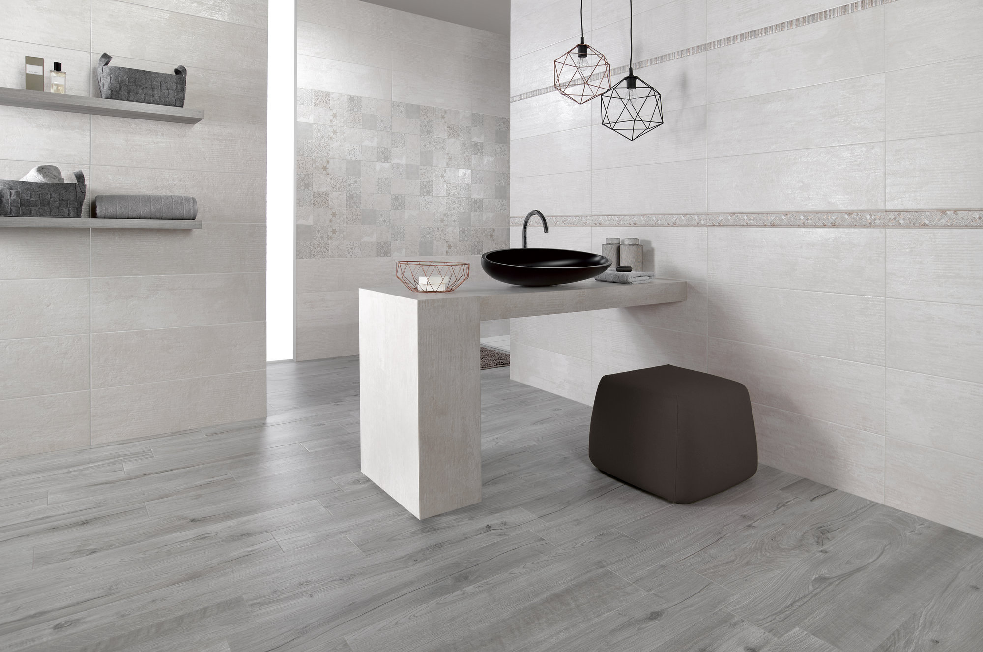 Szara łazienka z betonowym blatem z czarną umywalką nablatową, pufą, półkami wiszącymi na ścianie, dwoma lampami wiszącymi i płytkami imitującymi drewno na podłodze