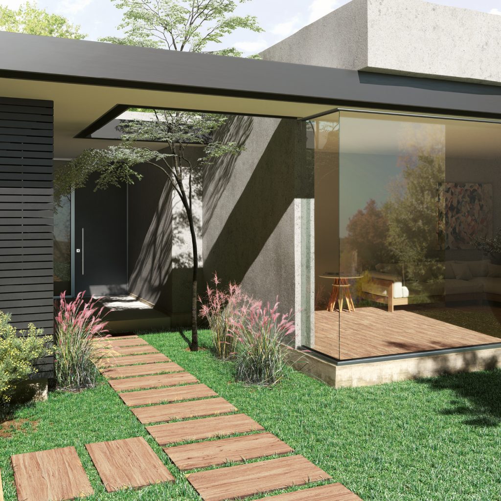 Elewacja nowoczesnego domu z trawą wokół niego i płytkami drewnopodobnymi Savana Outdoor, z których jest ułożona ścieżka