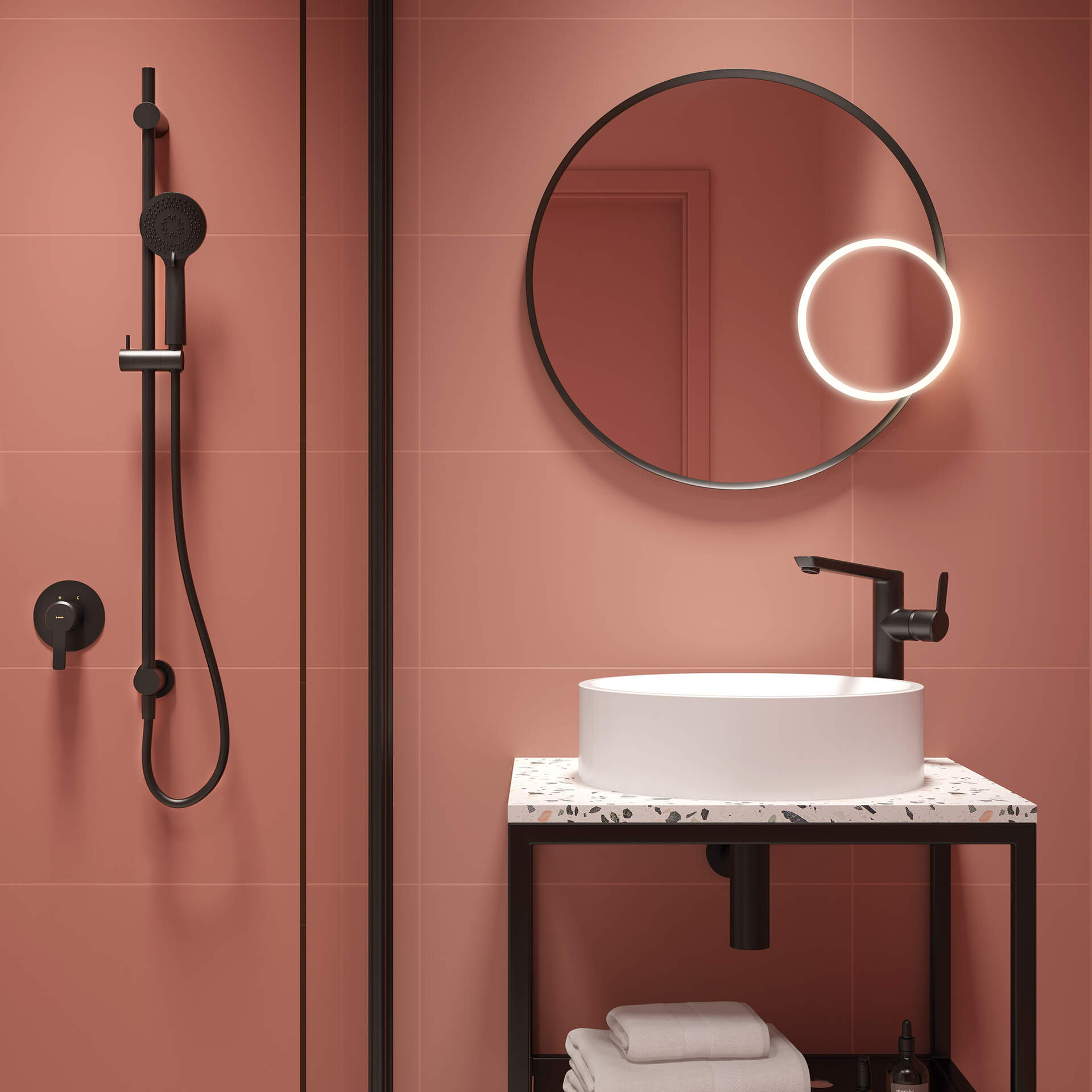 Różowa łazienka z kabiną prysznicową, kolorową półką lastryko z białą umywalką nablatową, okrągłym lustrem i czarną armaturą