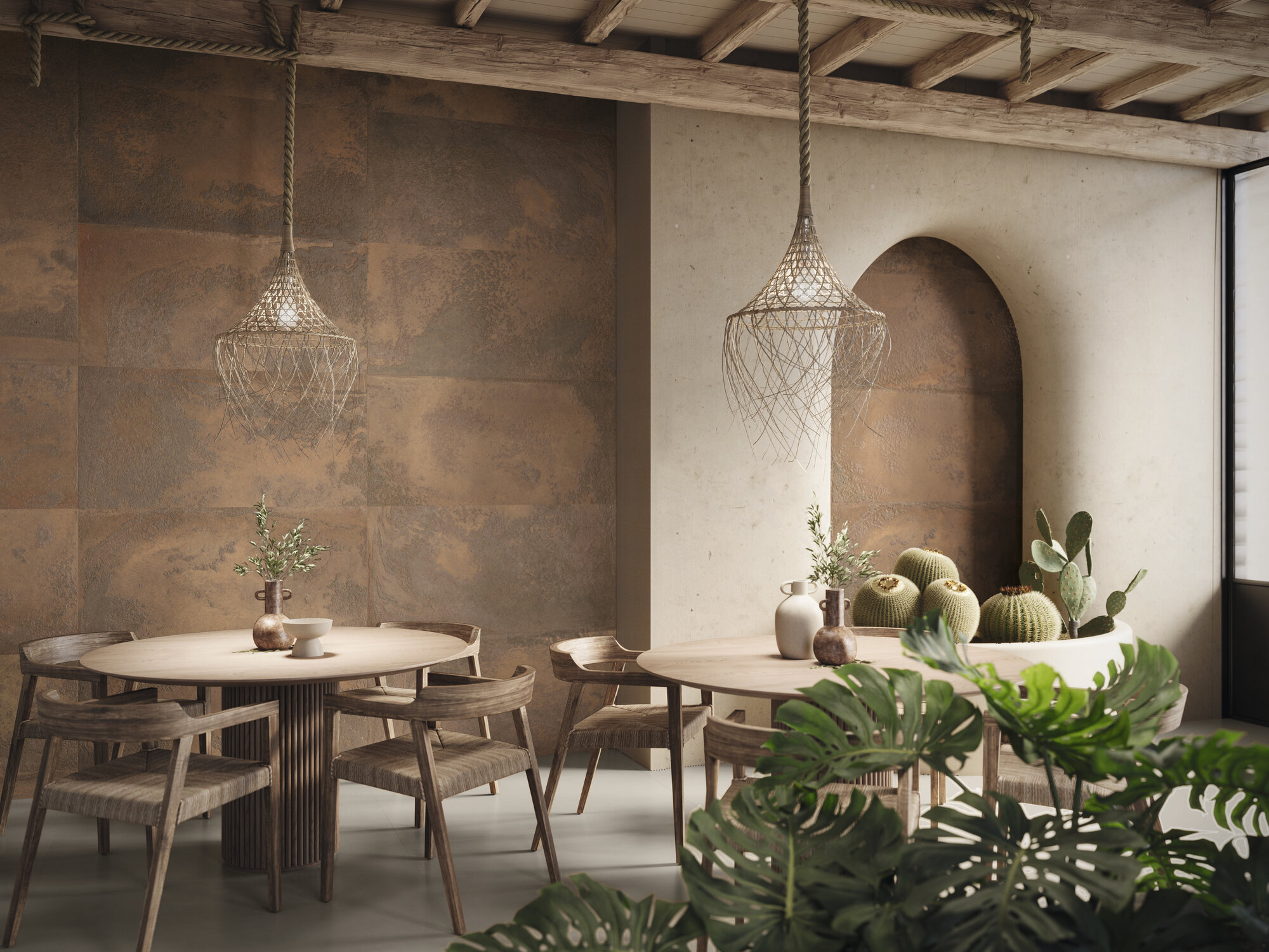 Restauracja z brązowymi płytkami imitującymi metal na ścianie, z okrągłymi stolikami z krzesłami i lampami wiszącymi