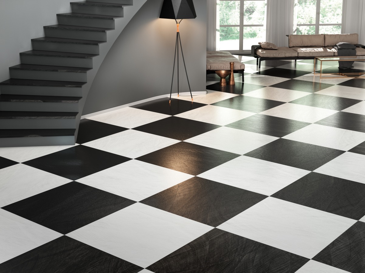 Duży przedpokój z podłogą w biało-czarną szachownicę, z dwoma kanapami, niskim stolikiem, lampą stojącą i schodami