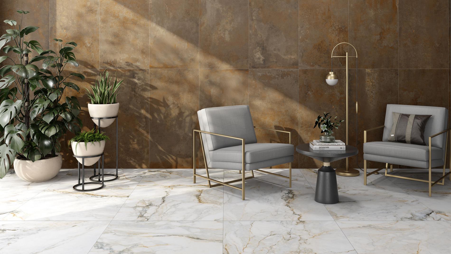 Elegancki pokój z podłogą wyłożoną płytkami imitującymi marmur i ścianą brązowymi płytkami imitującymi metal, z dwoma szarymi fotelami, okrągłym stolikiem, lampą stojącą i roślinami w donicach