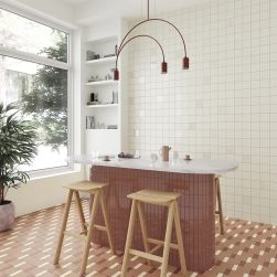 Kuchnia z wyspą wyłożoną brązowymi cegiełkami Bits Chestnut Gloss, z naczyniami, dwoma taboretami i lampą wiszącą