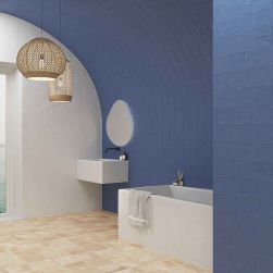 Rustykalna łazienka ze ścianami wyłożonymi granatowymi cegiełkami ze wzorami Casbah Decor Mix Indigo Matt, z wanną, ścienną umywalką, lustrem i lampami wiszącymi