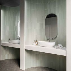 Łazienka z zaokrąglonymi wnękami wyłożonymi srebrnymi cegiełkami dekoracyjnymi Texiture Pattern Mix Silver Gloss, z białymi blatami z umywalkami i owalnymi lustrami