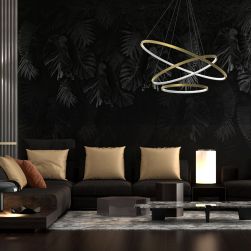 Ciemny salon z czarną tapetą na ścianie i brązową podłogą, czarną kanapą ze złotymi poduszkami, małymi stolikami i lampą wiszącą Rotonda Gold