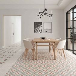 Jadalnia z płytkami patchworkowymi na podłodze Tesserae Play Board Duna, z drewnianym stołem, białymi krzesłami, lampą wiszącą i dwoma obrazami