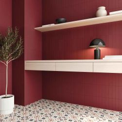 Pokój ze ścianami wyłożonymi czerwonymi cegiełkami bazowymi Texiture Garnet Matt, z drewnianymi półkami z ozdobami i kwiatem w donicy