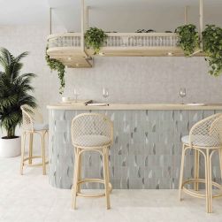 Restauracja z ladą wyłożoną szarymi cegiełkami dekoracyjnymi Cosmic Grey, z trzema krzesłami, zastawą i wiszącą półką z roślinami
