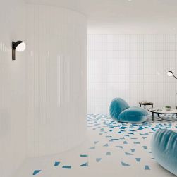 Biało-niebieskie pomieszczenie ze ścianą wyłożoną białymi cegiełkami 3D w połysku Stripes Ice White Gloss z niebieskimi fotelami i małymi, okrągłymi stolikami