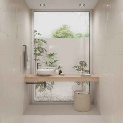 Mała, beżowa łazienka ze ścianami wyłożonymi cegiełkami ściennymi Grace Sand Matt, z wiszącym blatem drewnianym z białą umywalką nablatową, wiklinowym koszem i ręcznikiem na ścianie