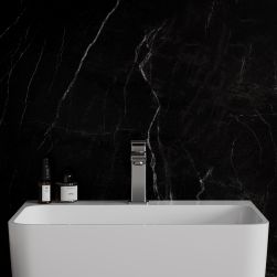 Widok od przodu na białą umywalkę z baterią stojącą w kolorze niklu Omnires Parma na tle czarnej ściany