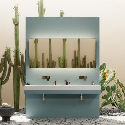 Kolorowa łazienka z podłogą lastryko, dużymi kaktusami, niebieską ścianką na środku z umywalkami i dwoma bateriami podtynkowymi Omnires Fresh oraz dużym lustrem