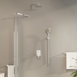 Beżowa ściana łazienki ze ścianą prysznicową, zestawem prysznicowym podtynkowym Parma, z białym ręcznikiem wiszącym na podłużnym wieszaku