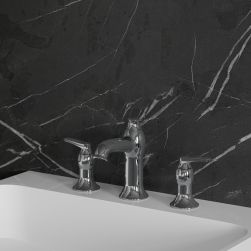 Widok z boku na białą umywalkę z baterią 3-otworową w chromie Omnires Art Deco na tle ciemnej ściany z jasnymi żyłami