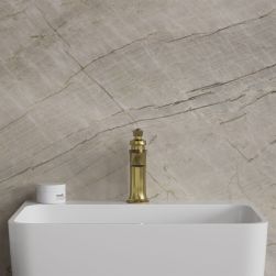Bateria umywalkowa Armance w kolorze mosiądzu szczotkowanego stojąca na białej umywalce