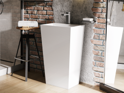 Biała umywalka wolnostojąca prostokątna Besco Vera z baterią stojącą na jasnej, drewnianej podłodze i na tle ceglanej ściany