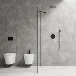 Nowoczesna i minimalistyczna łazienka wyłożona szarymi płytkami imitującymi kamień z białą, wiszącą miską WC i bidetem z czarną baterią, ze ścianą prysznicową i czarnym zestawem prysznicowym podtynkowym Y