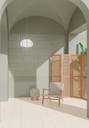 Przestronny korytarz ze ścianą wyłożoną szaro-miętowymi cegiełkami w połysku Aquarelle O Mint Grey z fotelem i pufą, parawanem oraz lampą wiszącą