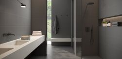 Ciemna, elegancka łazienka z kabiną prysznicową, białą półką wiszącą, lampą, ręcznikiem wiszącym na ścianie i płytkami z kolekcji Carpenter
