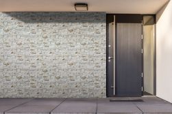 Front domu z ciemnymi, brązowymi drzwiami i kamieniem elewacyjnym Basalto Natural