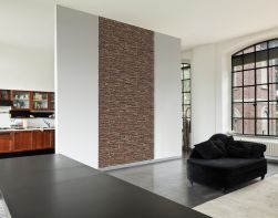 Salon z czarną, aksamitną kanapą oddzielony od kuchni białą ścianka z kamieniem dekoracyjnym Davos Copper