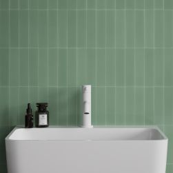 Biała bateria umywalkowa stojąca Omnires Y na tle zielonej ściany