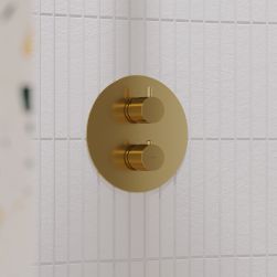 Bateria natryskowa podtynkowa z termostatem z kolekcji Y w kolorze złota szczotkowanego na białej ścianie w kabinie prysznicowej