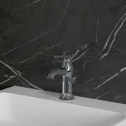 Widok z boku na baterię umywalkową w chromie Omnires Art Deco stojącą na białej umywalce na tle ciemnej ściany z jasnymi żyłami