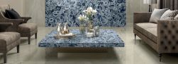 Elegancki salon z niebieskimi, dekoracyjnymi płytkami imitującymi kamień Agata Maxfine Blu Bright, z kanapą, dwoma fotelami i stolikiem