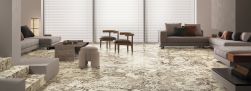 Salon z podłogą wyłożoną beżowymi płytkami imitującymi kamień Graniti Maxfine Alaska White, z dwiema beżowymi kanapami, stolikiem i krzesłami