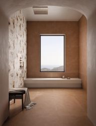 Pomieszczenie wyłożone płytkami imitującymi beton All Around Concrete Earth, z oknem, prysznicem i ławą