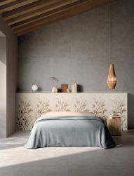 Sypialnia wyłożona szarymi płytkami imitującymi beton All Around Concrete Grey, z łóżkiem i ozdobami