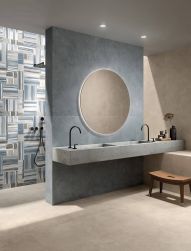 Łazienka z płytkami dekoracyjnymi All Around Wall Blue Impression na ścianie z prysznicem, podwójną umywalką ścienną i okrągłym lustrem