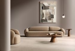 Salon z podłogą wyłożoną beżowymi płytkami imitującymi beton All Around Concrete Sand, z kanapą, fotelem, małym stolikiem i obrazem