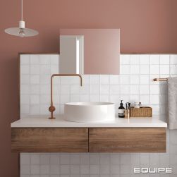 Romantyczna łazienka z różową ścianą i ścianką wyłożoną białymi cegiełkami z kolekcji Altea, z wiszącą szafką drewnianą z białym blatem, okrągłą umywalką nablatową, baterią stojącą, kwadratowym lustrem i lampą wiszącą