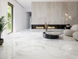 nowoczesny jasny salo, duże okno, duży kominek, wygodna kanapa, na podłodze płytki basil white pulido