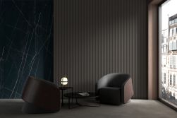 Ciemny pokój ze ścianą wyłożoną czarnymi płytkami 3D Tornares RLV Zumaia Black z dwoma fotelami i okrągłym stolikiem
