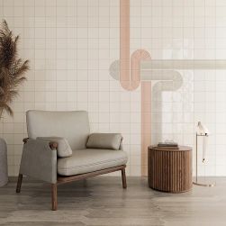 Pok&oacute;j z drewnianą podłogą i dekoracyjnymi cegiełkami w połysku Er Vapor Mint Grey Gloss na ścianie, z fotelem, okrągłym stolikiem i małą lampą stojącą