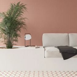 Pomieszczenie z pomarańczowymi płytkami TP Med Cotto Matt na ścianie, z poduszkami do siedzenia, lampką i kwiatem