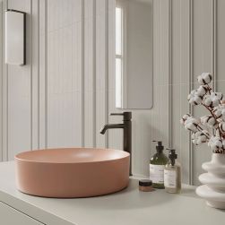 Ściana w łazience wyłożona płytkami Faces Liso Grey z różową umywalką nablatową