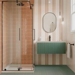 Łazienka ze ścianą pod prysznicem wyłożoną pomarańczowymi cegiełkami w połysku T Toffee Gloss, z wiszącą półką zieloną z umywalką i lustrem