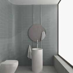 Minimalistyczna łazienka ze ścianami wyłożonymi szarymi płytkami trójwymiarowymi Sweet Bars Mineral Grey Gloss z białą miską WC, białą umywalką stojącą i okrągłym lustrem