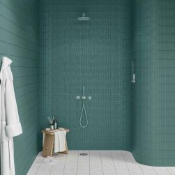 Ściany prysznica wyłożone zielonymi płytkami trójwymiarowymi Sweet Bars Teal Matt z zielonym zestawem natryskowym, małym taboretem i szlafrokiem